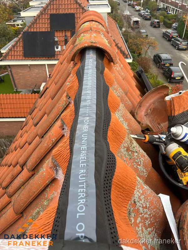 Dakdekker vervangt nokvorst met ruiterrol op pannendak in Franeker
