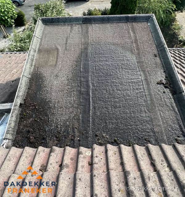 Verouderd plat dak met bitumen en slijtage voor lekkage inspectie in Franeker Verouderd plat dak met bitumen en slijtage voor lekkage inspectie in Franeker