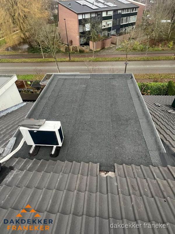 Plat dak inspectie met bitumen bedekking naast schuin pannendak in Franeker Plat dak inspectie met bitumen bedekking naast schuin pannendak in Franeker