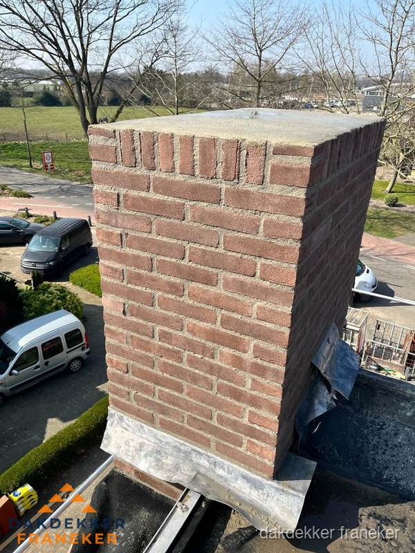 Gemetselde schoorsteen met loodaansluiting op dak in Franeker Gemetselde schoorsteen met loodaansluiting op dak in Franeker