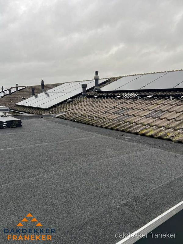 Bitumen dakbedekking op plat dak met aansluitend pannendak en zonnepanelen in Franeker
