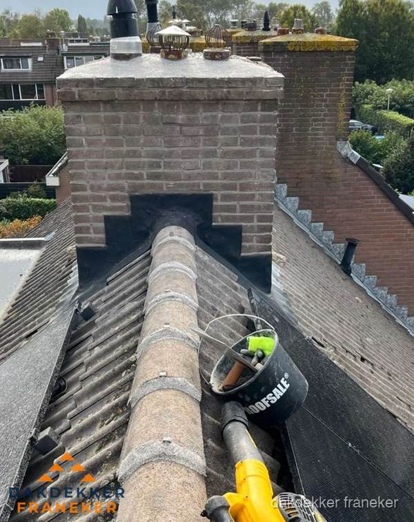 Schoorsteen met loodaansluiting en nokvorst op pannendak in Franeker Schoorsteen met loodaansluiting en nokvorst op pannendak in Franeker