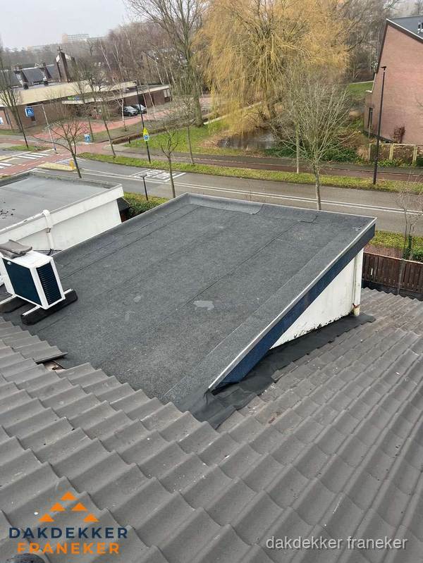 Plat dak met bitumen dakbedekking naast schuin pannendak in Franeker Plat dak met bitumen dakbedekking naast schuin pannendak in Franeker