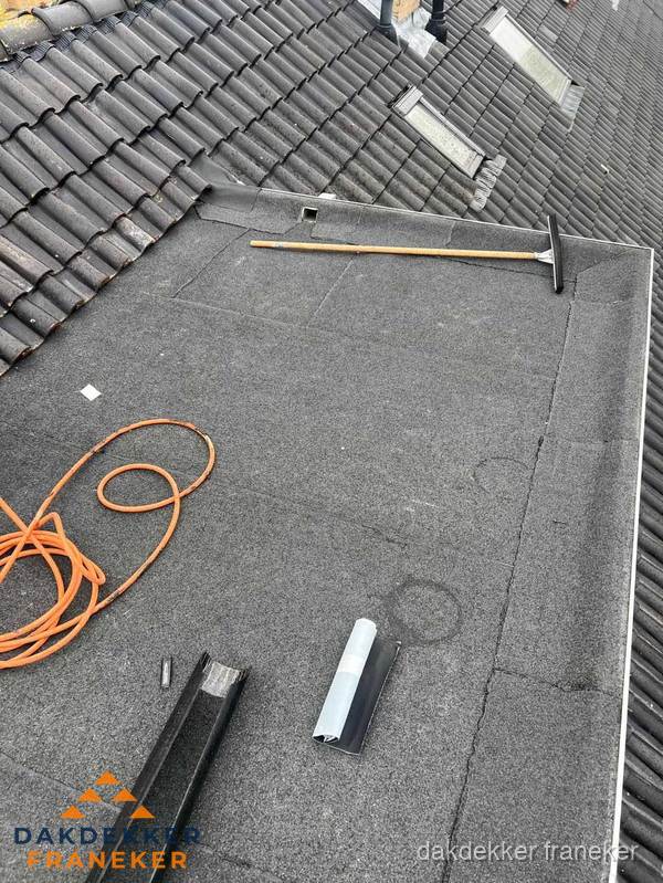 Plat dak reparatie met gereedschap en loodstroken in Franeker Plat dak reparatie met gereedschap en loodstroken in Franeker