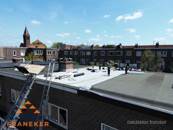 Dakdekkers aan het werk op plat dak in Franeker Dakdekkers aan het werk op plat dak in Franeker