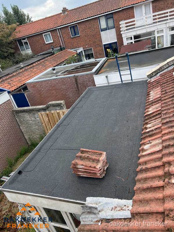 Plat dak aanbouw met bitumen naast schuin pannendak in Franeker Plat dak aanbouw met bitumen naast schuin pannendak in Franeker