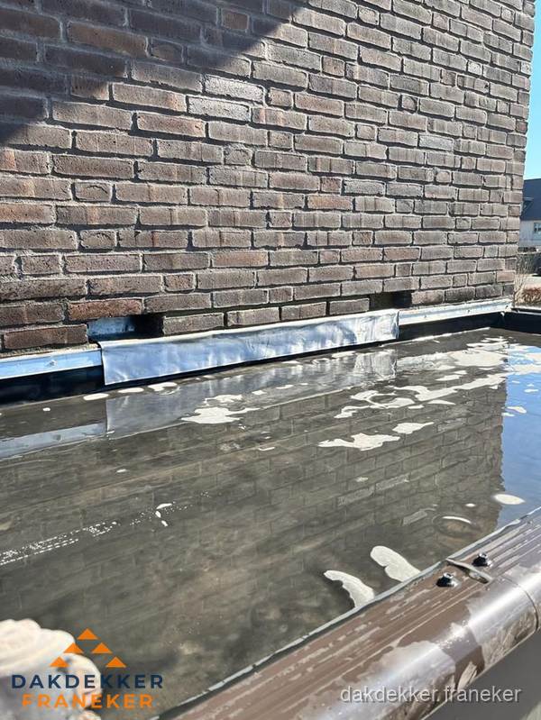 Stilstaand water op plat dak door slechte afwatering in Franeker Stilstaand water op plat dak door slechte afwatering in Franeker