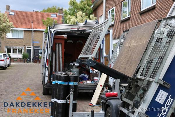 Dakdekkersbusje met materiaal en ladderlift voor dakpannen vervangen in Franeker