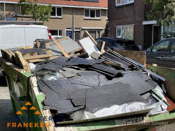 Afvalcontainer met gesloopt dakmateriaal tijdens dakkapel renovatie in Franeker Afvalcontainer met gesloopt dakmateriaal tijdens dakkapel renovatie in Franeker